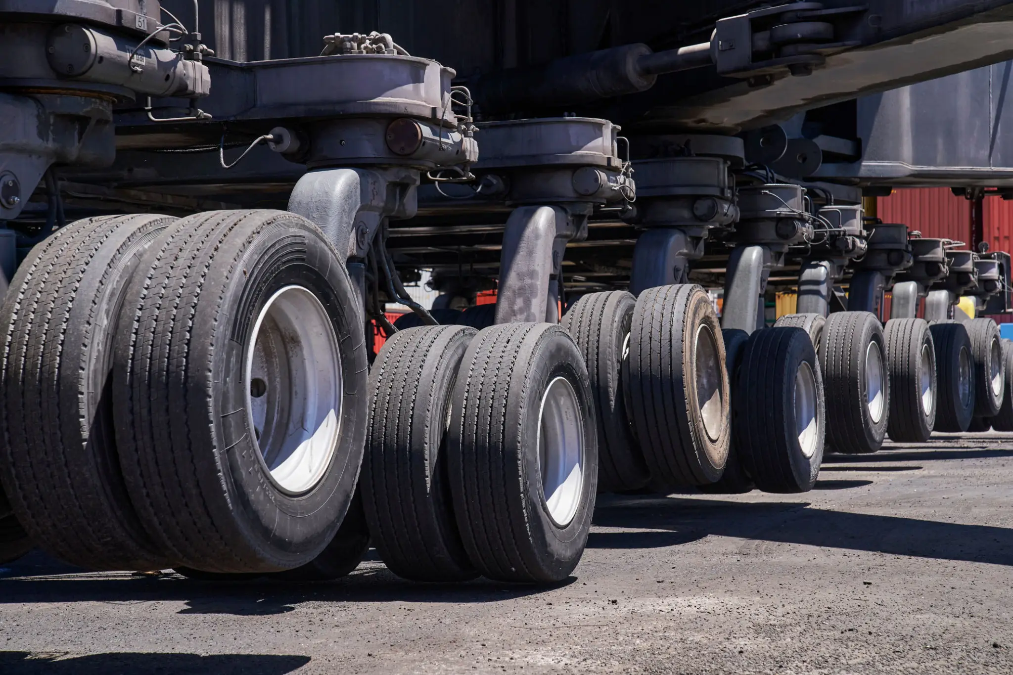 Close-up of airplane landing gear with multiple tires on tarmac.